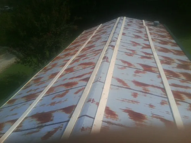Rusted metal roof panels with new wood purlins before replacement — Storm Damage Roof Repair in Mcchord Afb by Roofing Brothers
