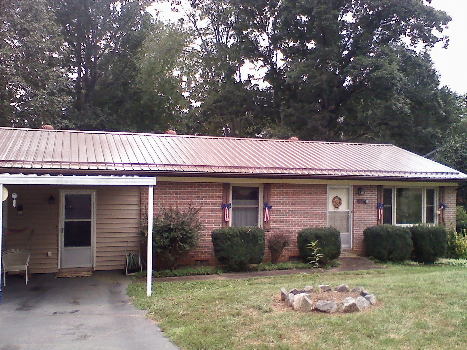 Bronze metal roof and carport on a brick ranch home — Roof Repair work by our crew in Mcchord Afb